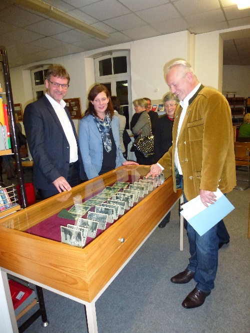 Bürgermeister Karl-Heinz Fitz, Büchereileiterin Carolin Beyer und Stadtarchivar Werner Mühlhäußer betrachten eines der Ausstellungsstücke